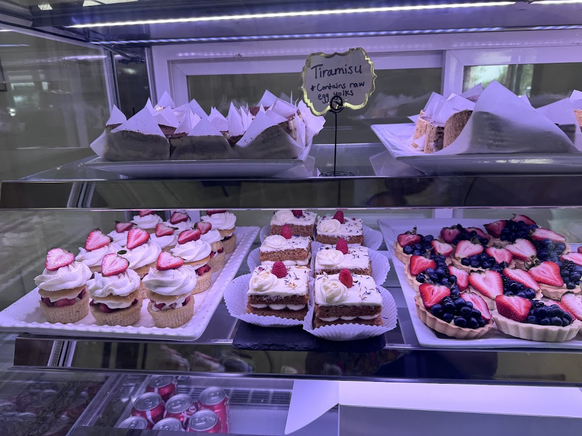Rows of colorful eclairs and berry pastries in the Café Magnolia case