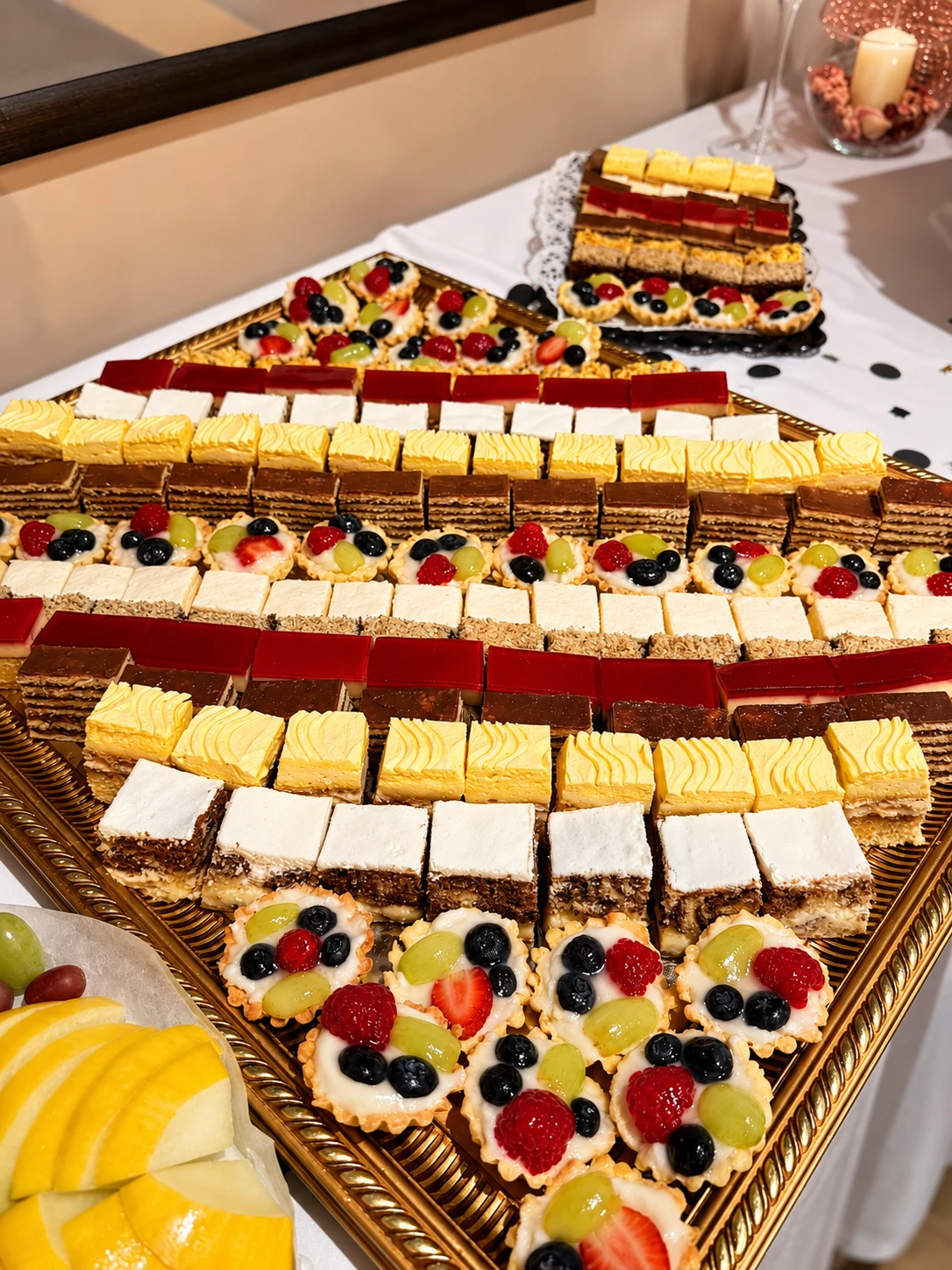 A gold tray of scratch-made European pastries at Café Magnolia — honey cake, custard slices and fresh fruit tartlets
